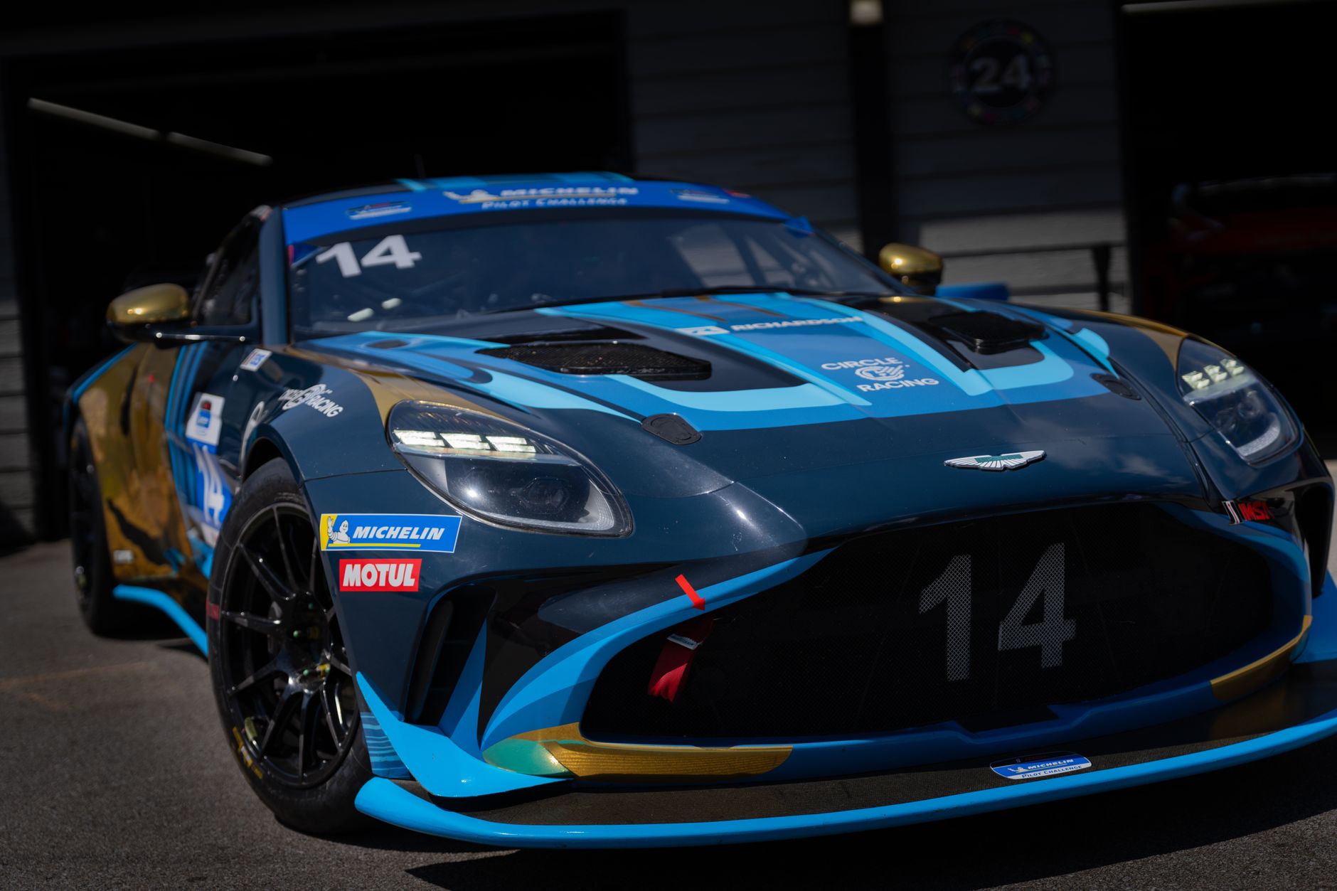 Close-up of a blue and gold race car parked on a track in Lexington, Ohio under sunlight.